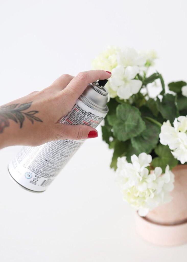 Applying UV Protection Spray to artificial plant