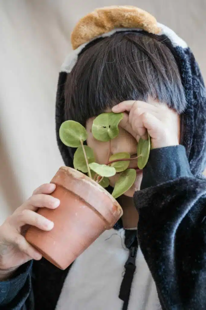 kid smelling a fake plant