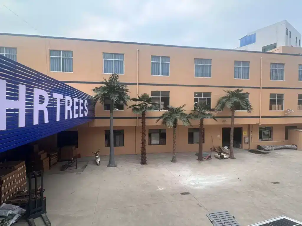 Outdoor artificial palm trees for large-scale commercial projects displayed in a factory courtyard